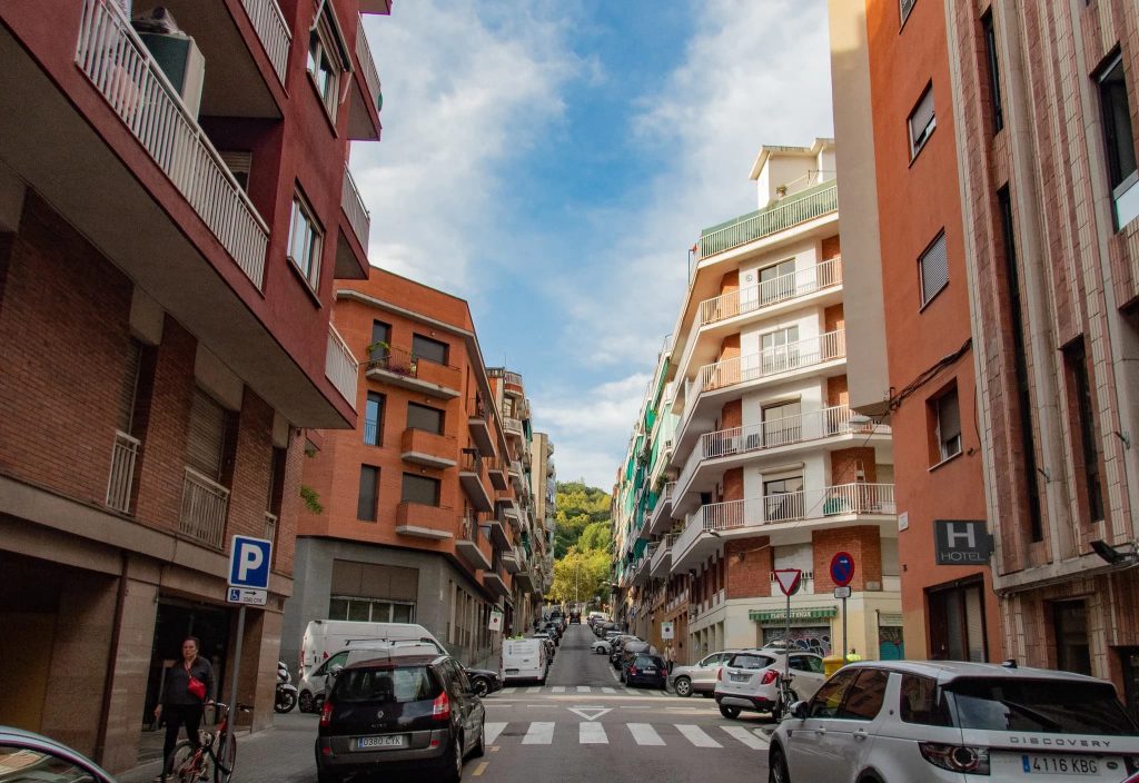 image Rue résidentielle à Barcelone avec des immeubles, des voitures garées et un passage piéton