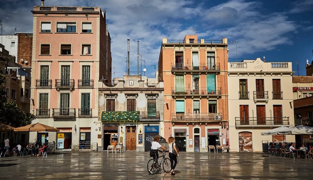Place du quartier de Gràcia à Barcelone avec des immeubles colorés et des terrasses